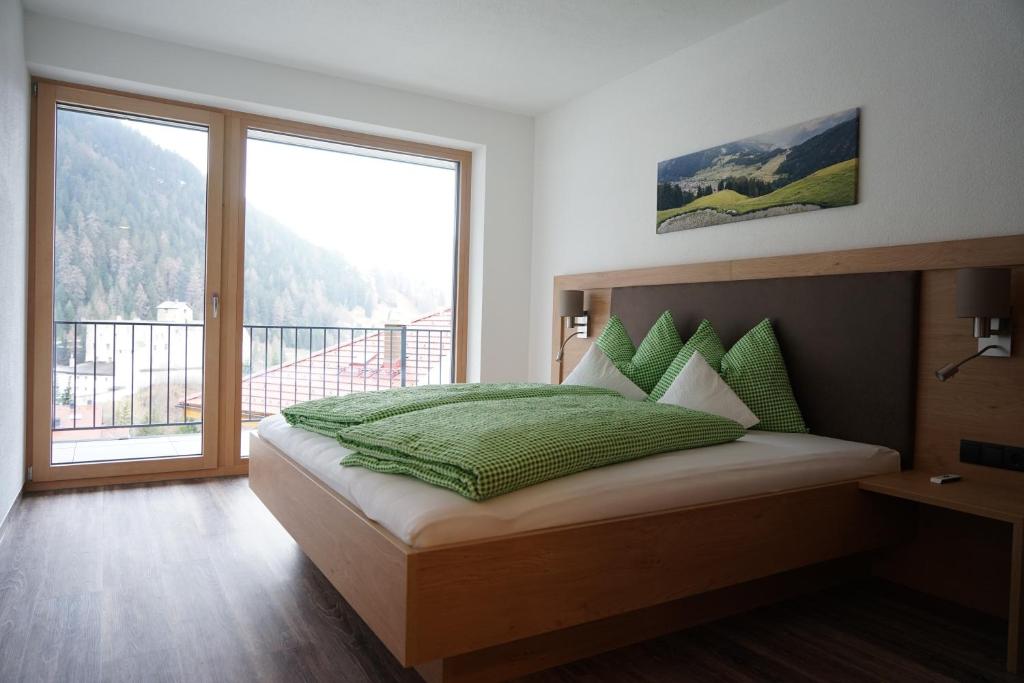 a bedroom with a bed and a large window at Schlossbichl in Nauders