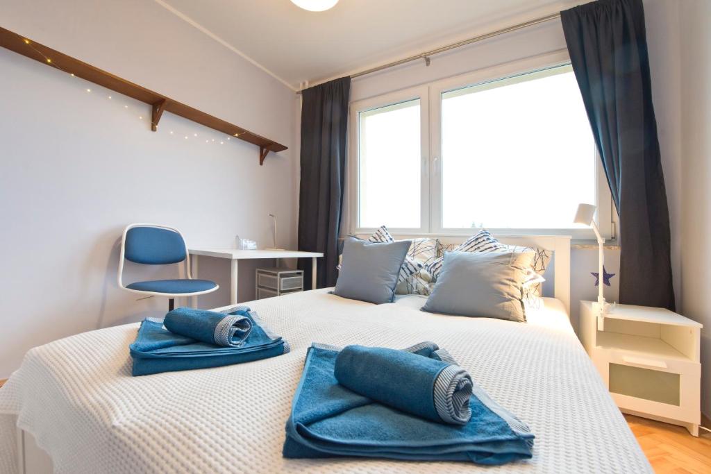 a bedroom with a large bed with blue towels on it at YOURAPART Zaspa in Gdańsk