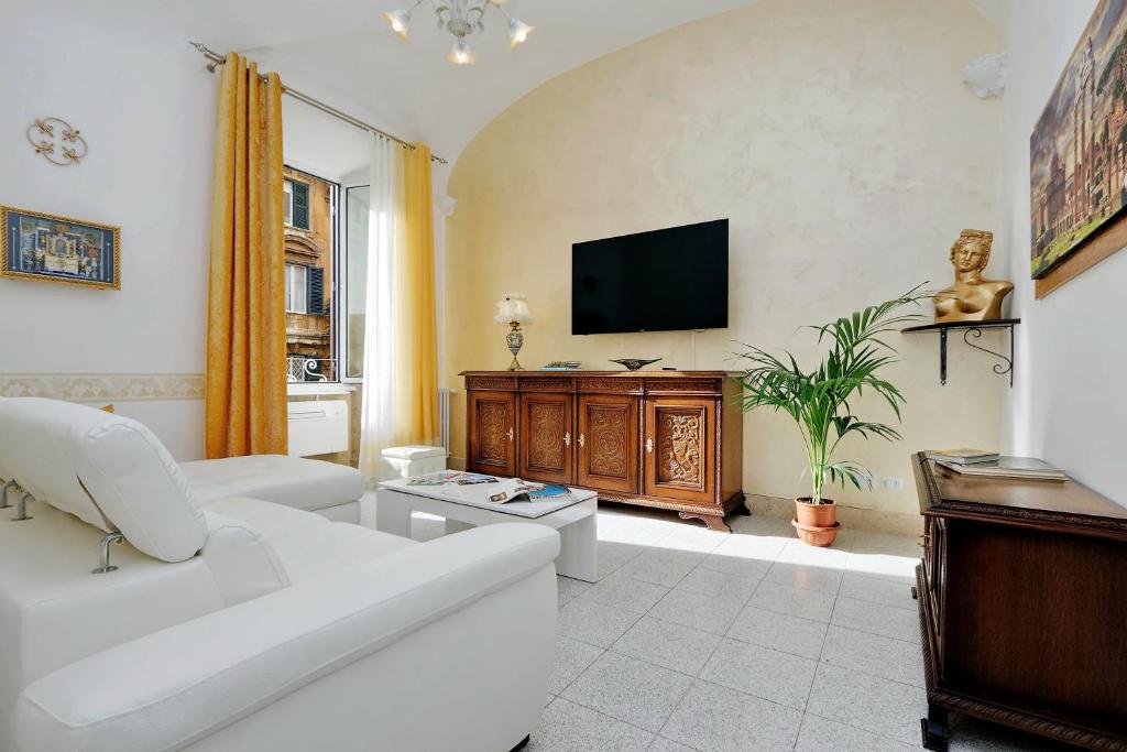 a living room with a white couch and a tv at GEMMA DOMUS in Rome