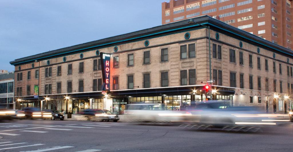 a building on a city street with cars driving past it at 11th Avenue Hostel in Denver