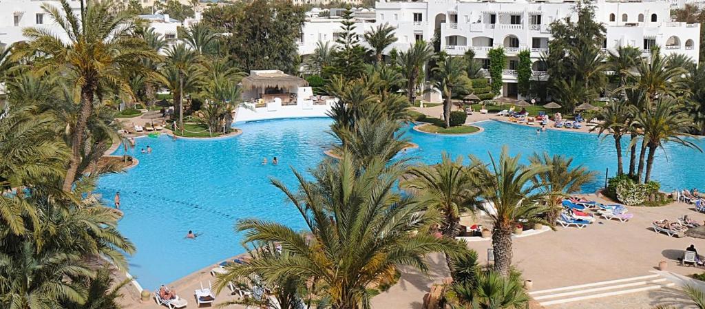an overhead view of a large swimming pool with palm trees at Djerba Resort- Families and Couples Only in Houmt Souk