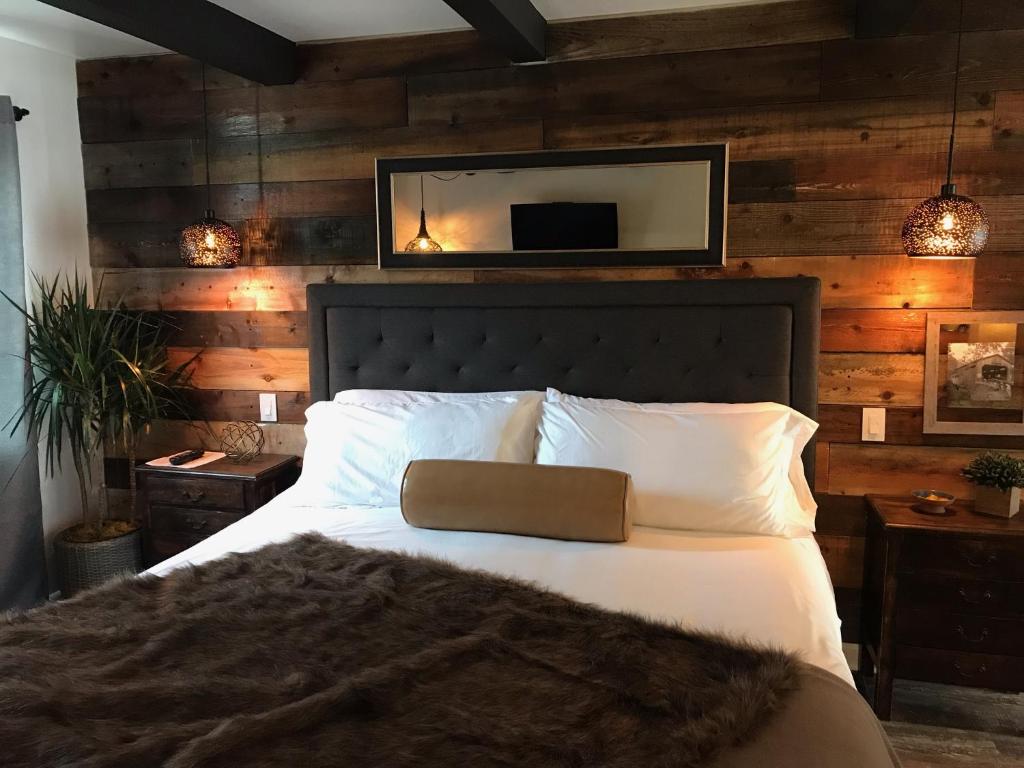 a bedroom with a bed and a mirror on the wall at Shell Beach Inn in Pismo Beach