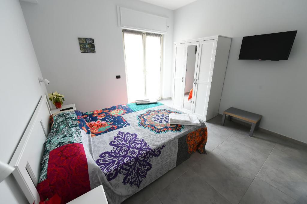 Un dormitorio con una cama con una colcha colorida. en B&B degli Aranci, en Pozzuoli