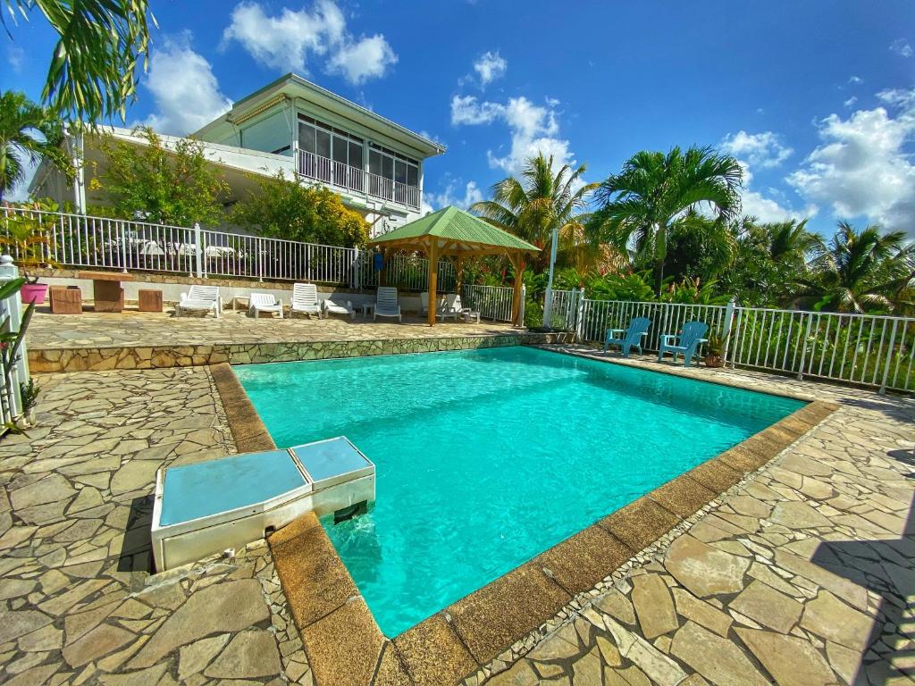 einen Pool im Hinterhof eines Hauses in der Unterkunft Résidence Paradis Tropical in Basse-Terre