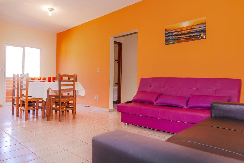a living room with a purple couch and a table at Apartamento Praia Grande Ubatuba 2 vagas garagem Internet WiFi in Ubatuba