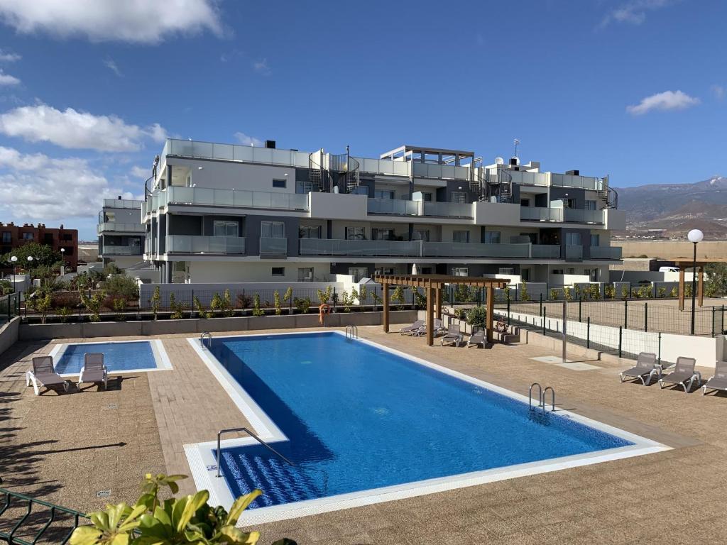 un immeuble avec une piscine devant un immeuble dans l'établissement Apartamento Nuevo Terrazas, à Granadilla de Abona