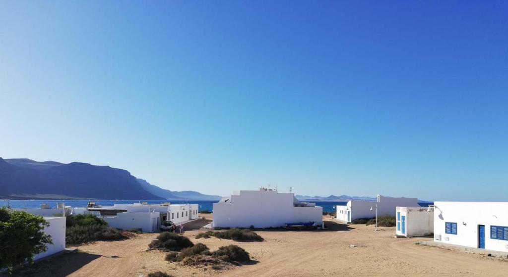 a row of white buildings with the ocean in the background at Samsara Home in Caleta de Sebo