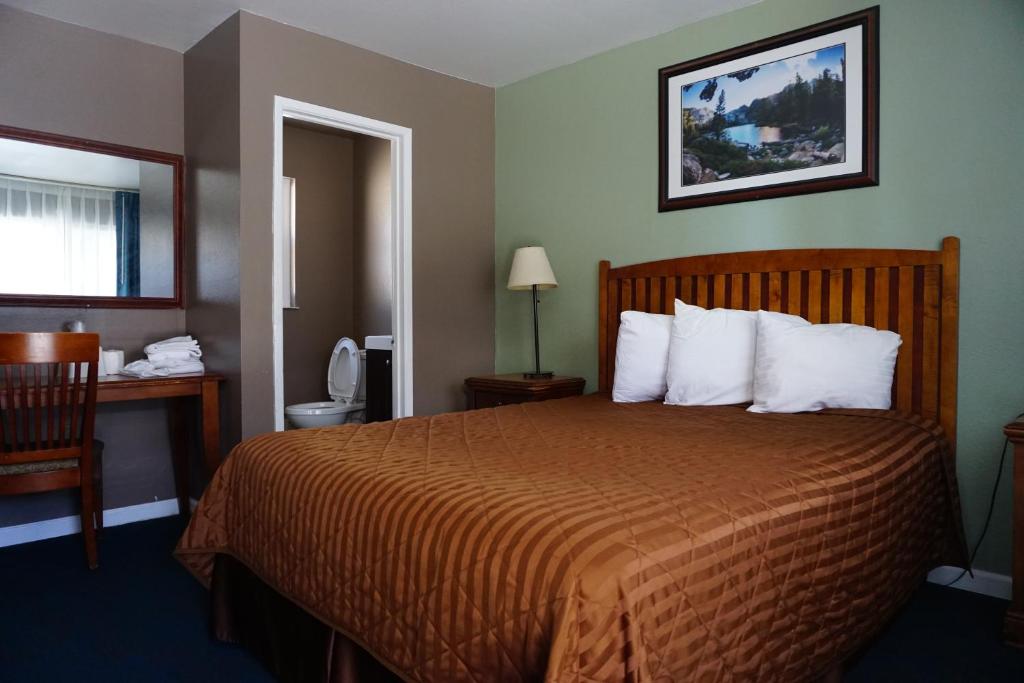 um quarto de hotel com uma cama com uma colcha laranja em A&A Lake Tahoe Inn em South Lake Tahoe