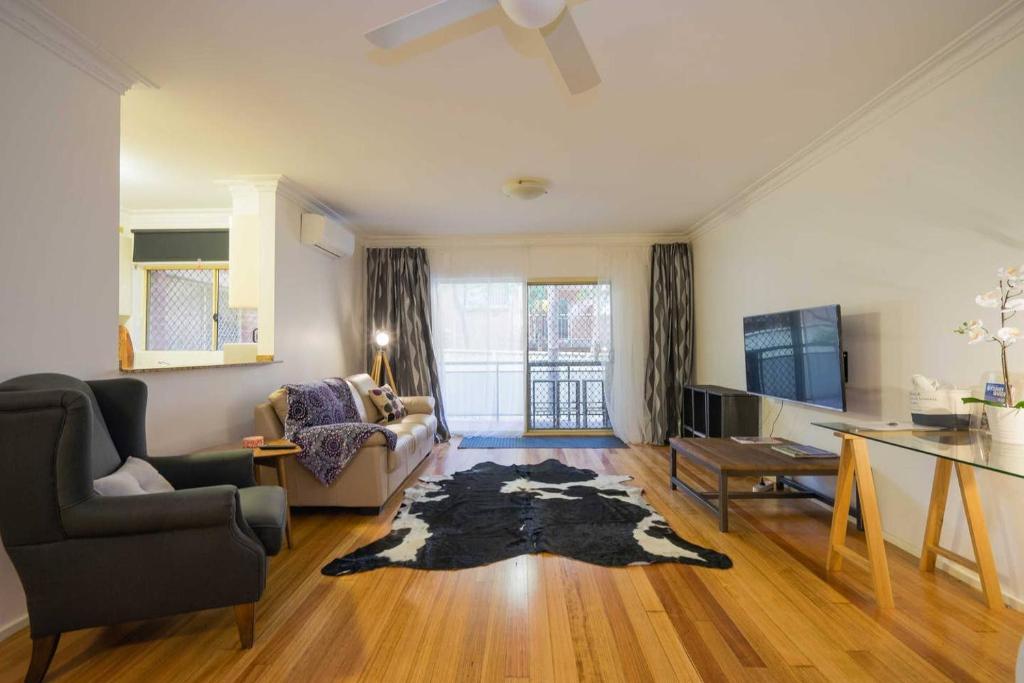 a living room with a couch and a tv at Urban Escape – Strathfield in Sydney
