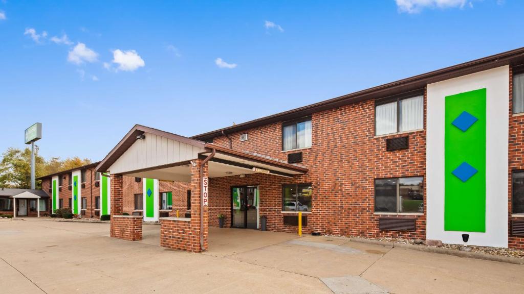 a brick building with a green sign on it at SureStay Hotel by Best Western Cedar Rapids in Cedar Rapids