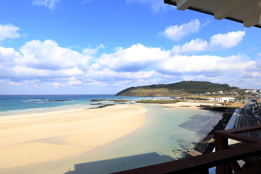 uma vista para a praia a partir da varanda de um resort em Ocean Grand Hotel em Jeju