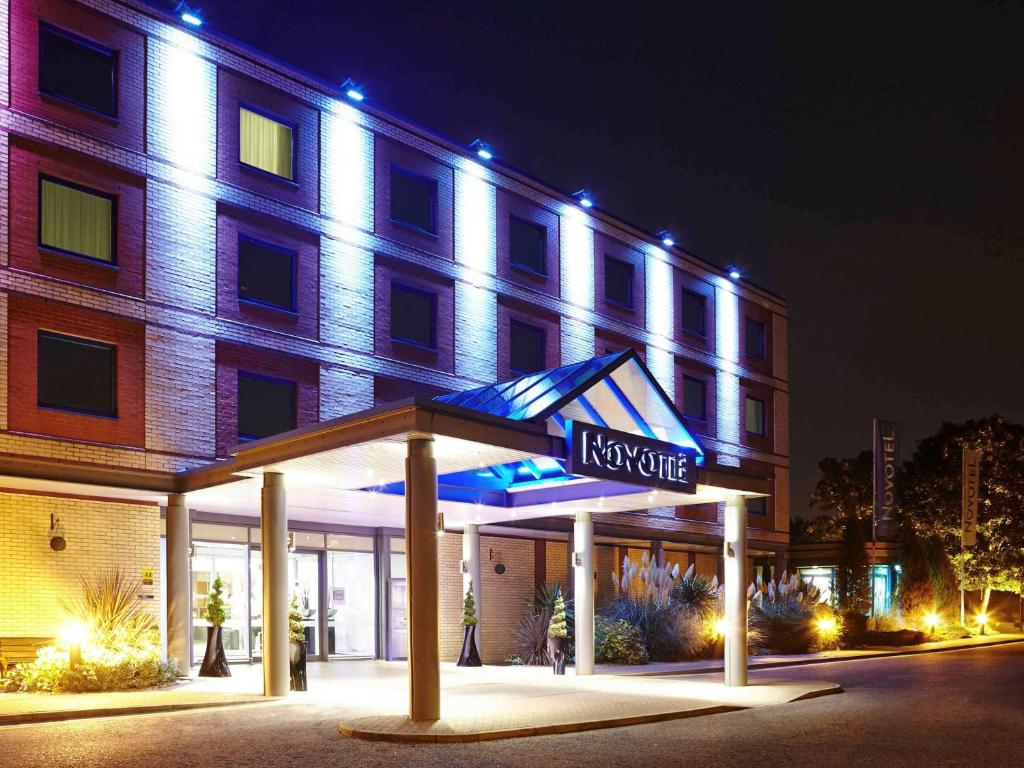 a large building with a neon sign on the side of it at Novotel London Heathrow Airport M4 Jct. 4 in Hillingdon