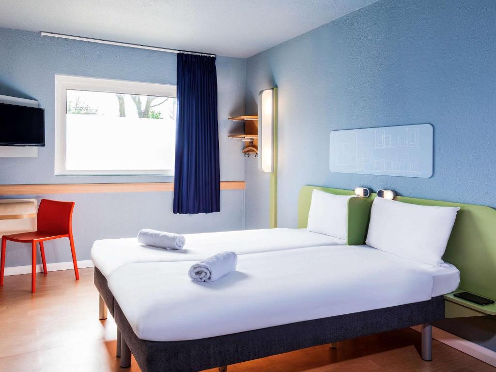 a room with a bed and a table and a chair at ibis budget London Barking in Barking