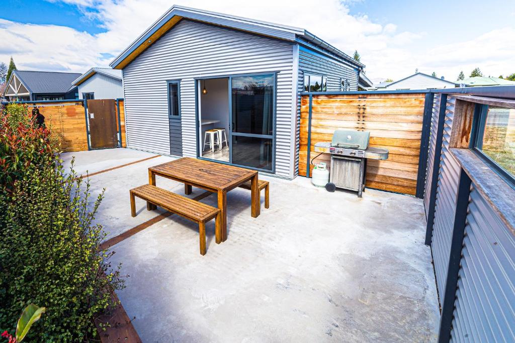 eine Terrasse mit einem Picknicktisch und einem Grill in der Unterkunft Twizel Cottages in Twizel