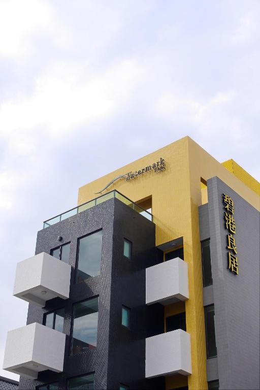 a yellow and black building with a sign on it at Watermark Hotel - Sizihwan in Kaohsiung