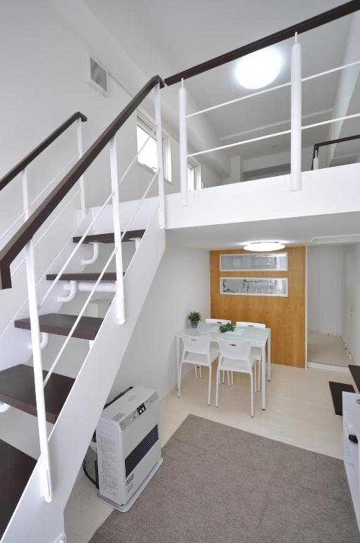 een witte woonkamer met een witte tafel en een trap bij Easy Access to downtown area, Sapporo Dome AMS503 in Sapporo