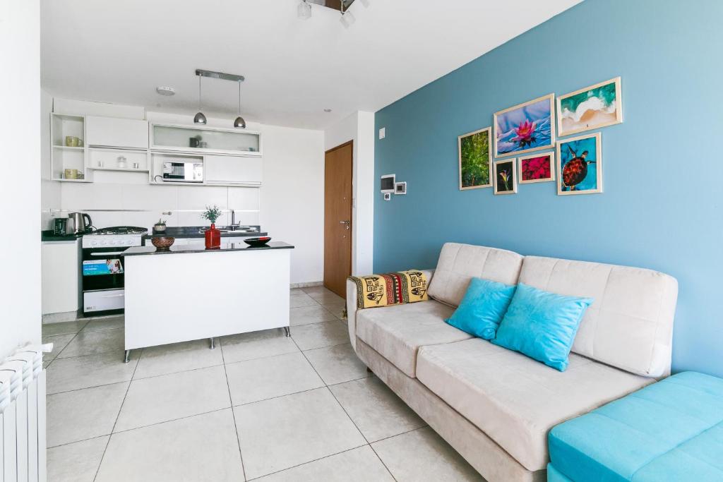 a living room with a couch and a kitchen at Apartamentos boutique Cordoba in Cordoba