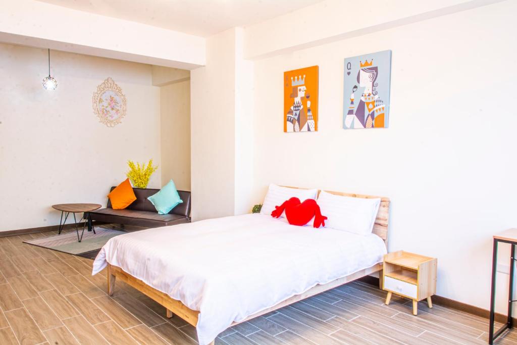 a bedroom with a white bed and a table at ioio in Tainan