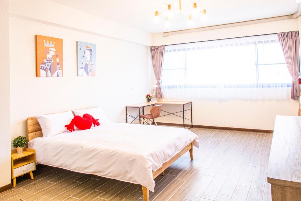 a bedroom with a large white bed and a window at ioio in Tainan