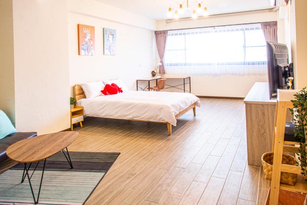 台南的住宿－ioio，一间卧室配有一张床、一张桌子和一台电视。
