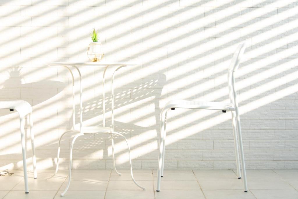 a white table with two chairs and a plant on it at ioio in Tainan