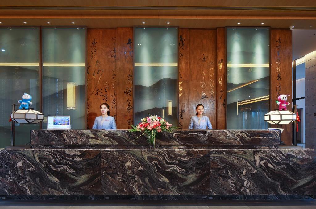 three women standing behind a counter in a building at Crowne Plaza Nanchang Wanli, an IHG Hotel in Nanchang