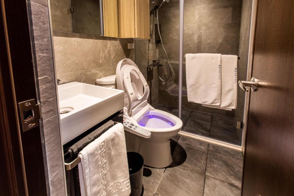 a small bathroom with a toilet and a sink at Alishan Shermuh Tourist Hotel in Zhongzheng