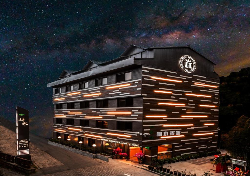 中正区にあるAlishan Shermuh Tourist Hotelの夜時計付きの建物