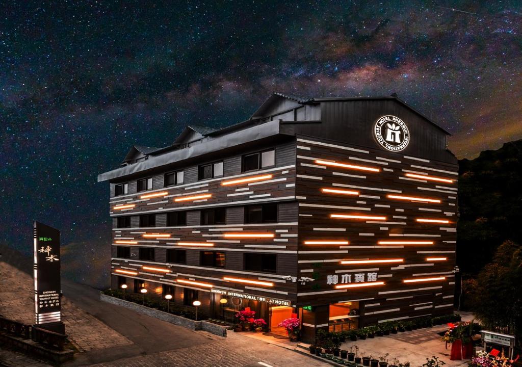 a building with a clock on it at night at Alishan Shermuh Tourist Hotel in Zhongzheng