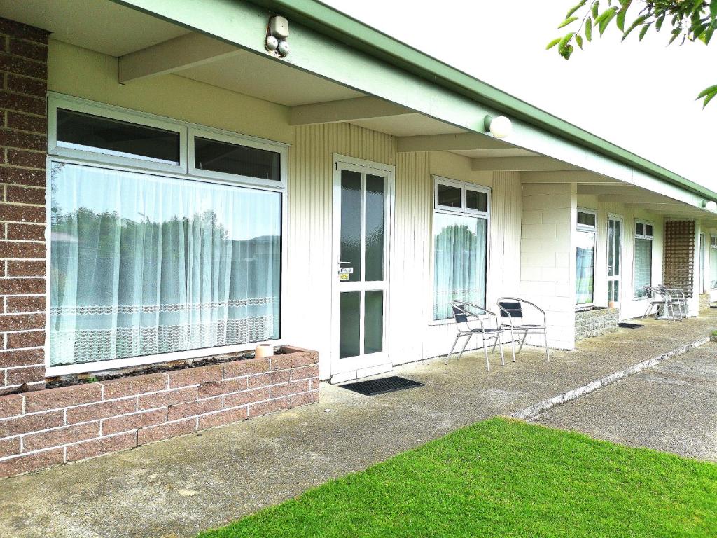 a house with a patio with chairs and windows at 45 on Avenal Motel in Invercargill