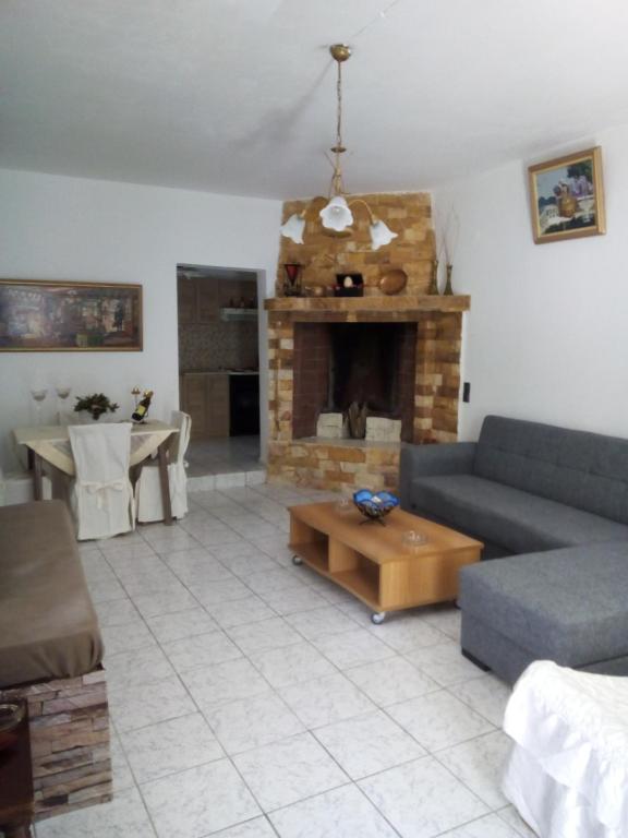 - un salon avec un canapé et une cheminée dans l'établissement Aggelina, à Sárkhos
