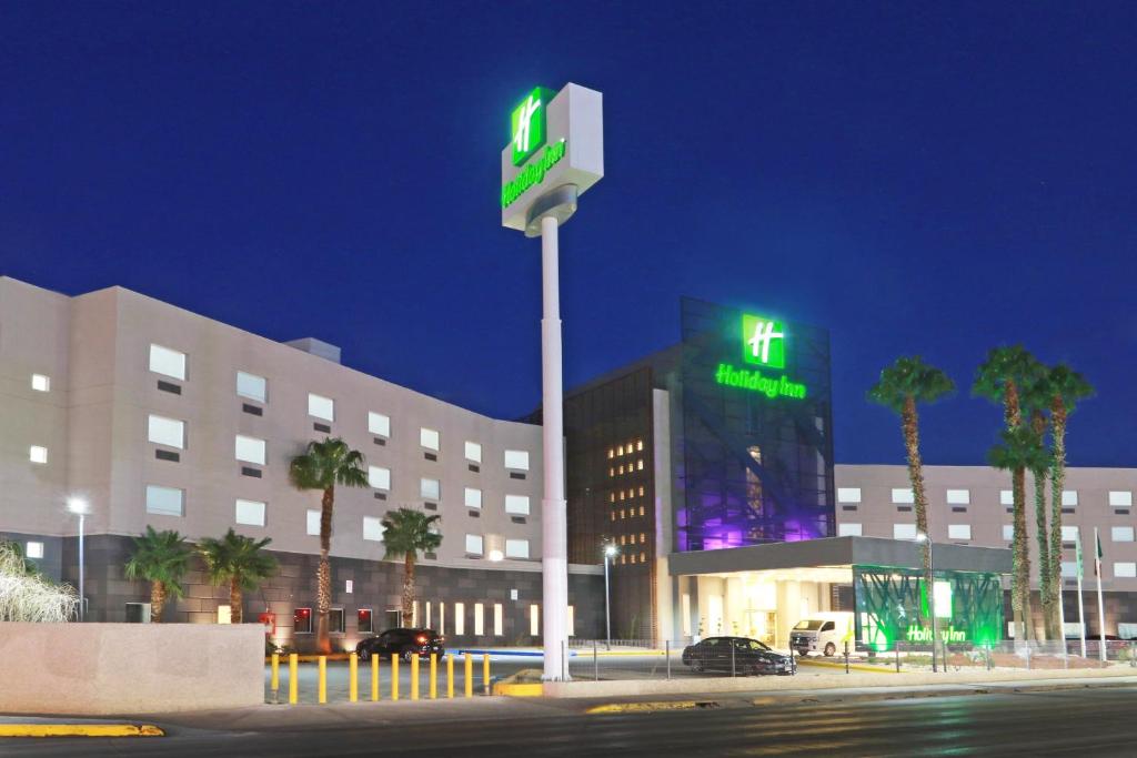 - un bâtiment avec un hôtel muni d'un panneau vert dans l'établissement Holiday Inn - Ciudad Juarez, an IHG Hotel, à Ciudad Juárez