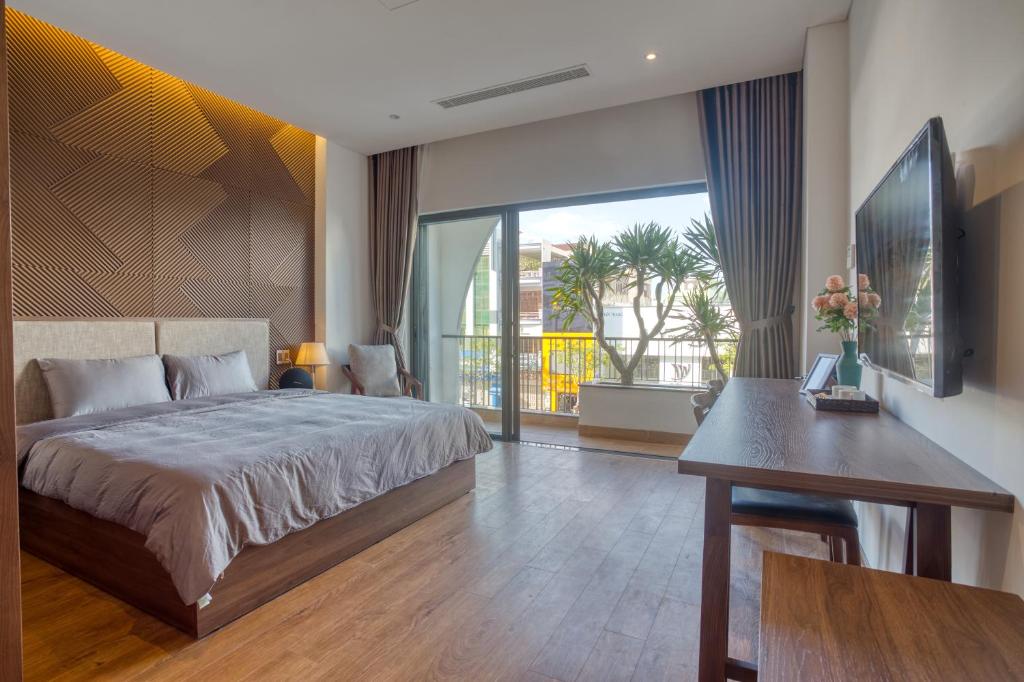 峴港的住宿－Oriental Danang，一间卧室配有一张床、一张桌子和一张书桌