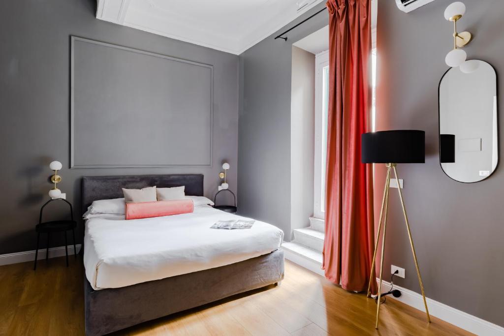 una camera con letto e tenda rossa di Suites by Chloe a Roma