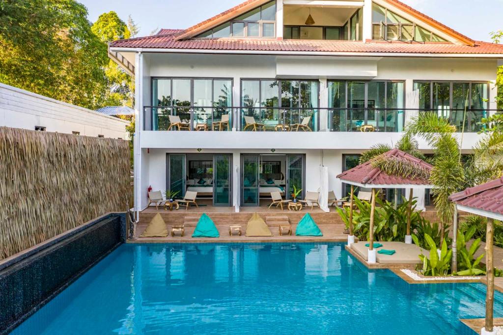 una villa con piscina di fronte a una casa di By The Sea Koh Mak Boutique Guesthouse a Ko Mak