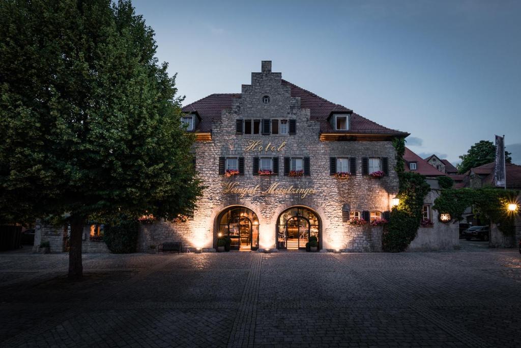 ein großes Steingebäude mit einem Schild darauf in der Unterkunft Hotel / Weingut Meintzinger in Frickenhausen