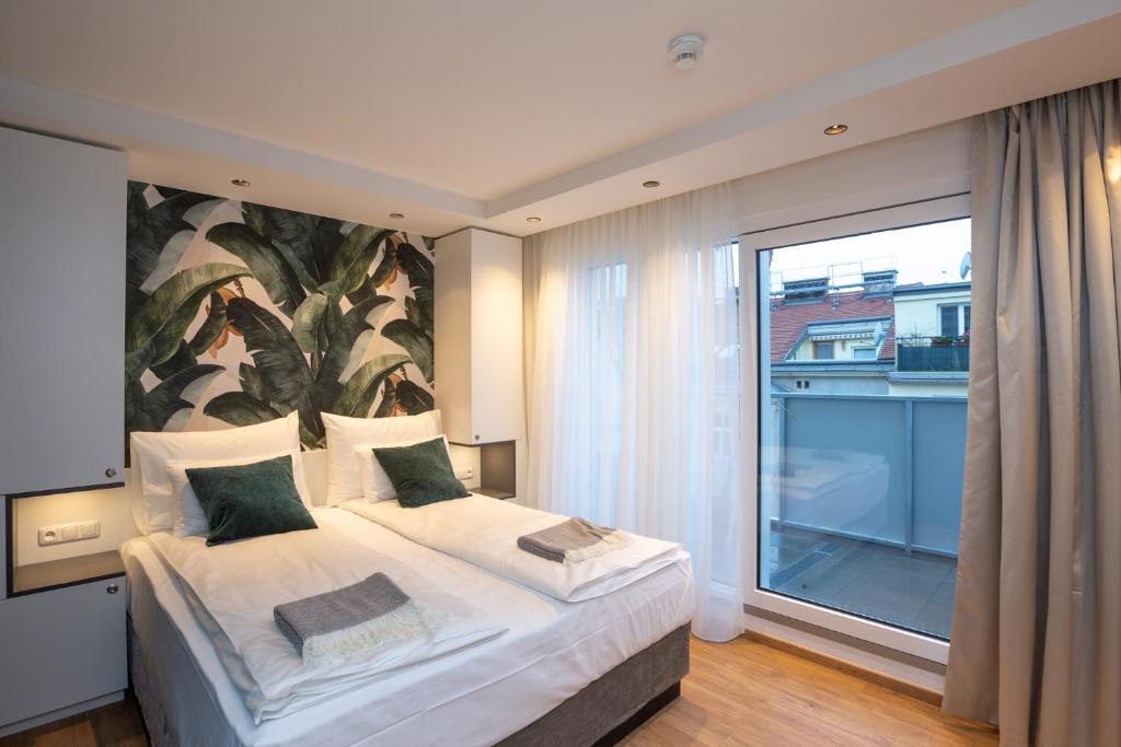 a bedroom with a bed and a large window at Wilmas Apartments by Arbio in Vienna