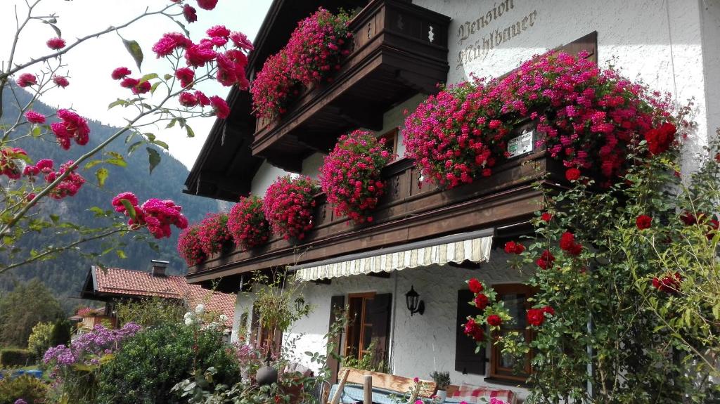 un bâtiment avec des fleurs sur son côté dans l'établissement Pension Mühlbauer, à Bayrischzell