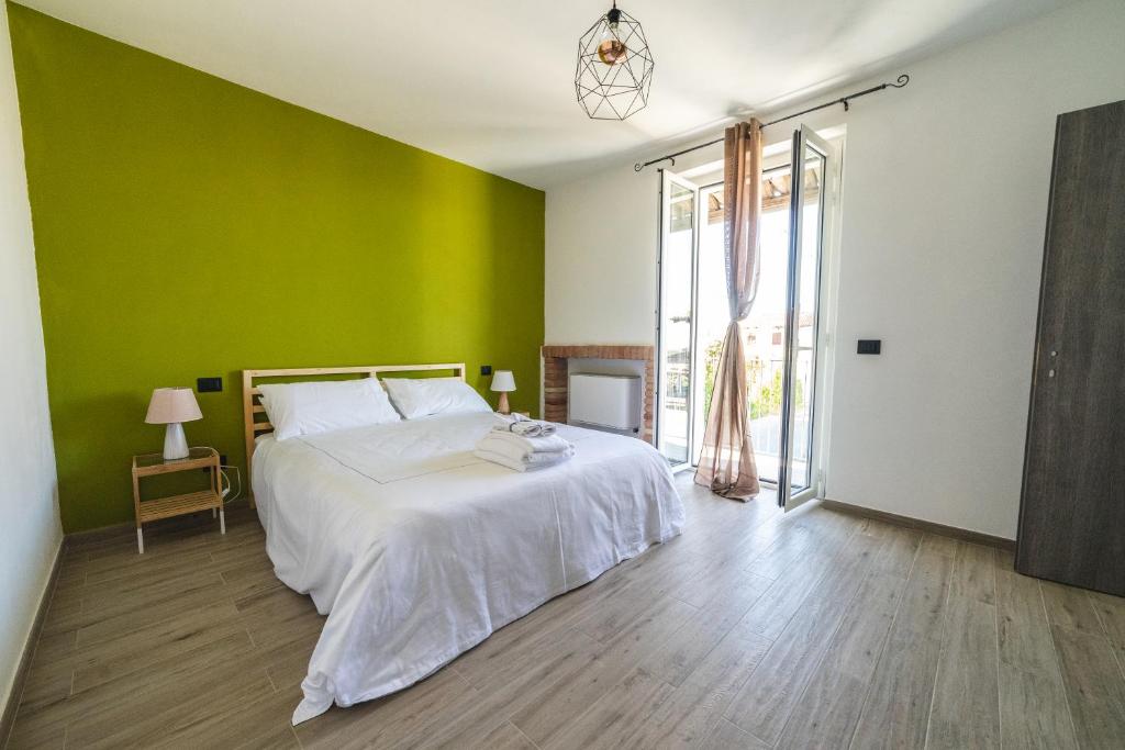 Un dormitorio con una pared verde y una cama en Locanda Stardé, en Neive