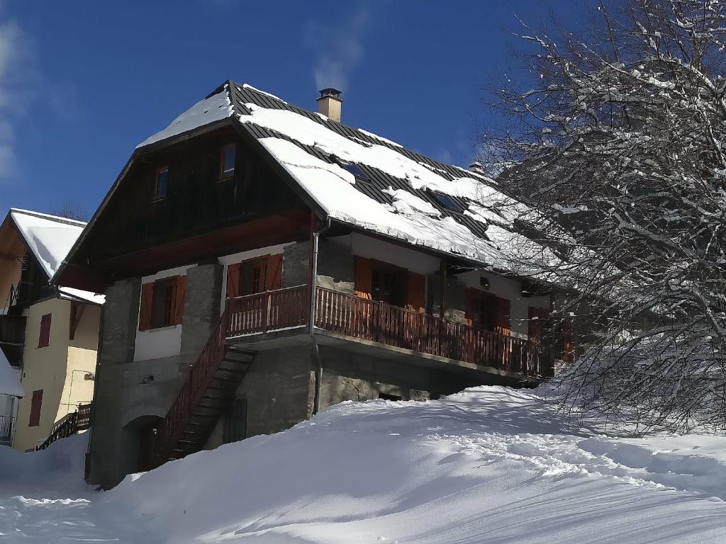 een huis met een met sneeuw bedekt dak in de sneeuw bij Chalet Savoiage in Saint-Colomban-des-Villards