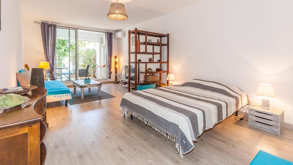 una camera con letto e un soggiorno di Grand T1 avec terrasse à 5min des plages et 400m de St Gilles Les Bains a Saint-Gilles-les Bains