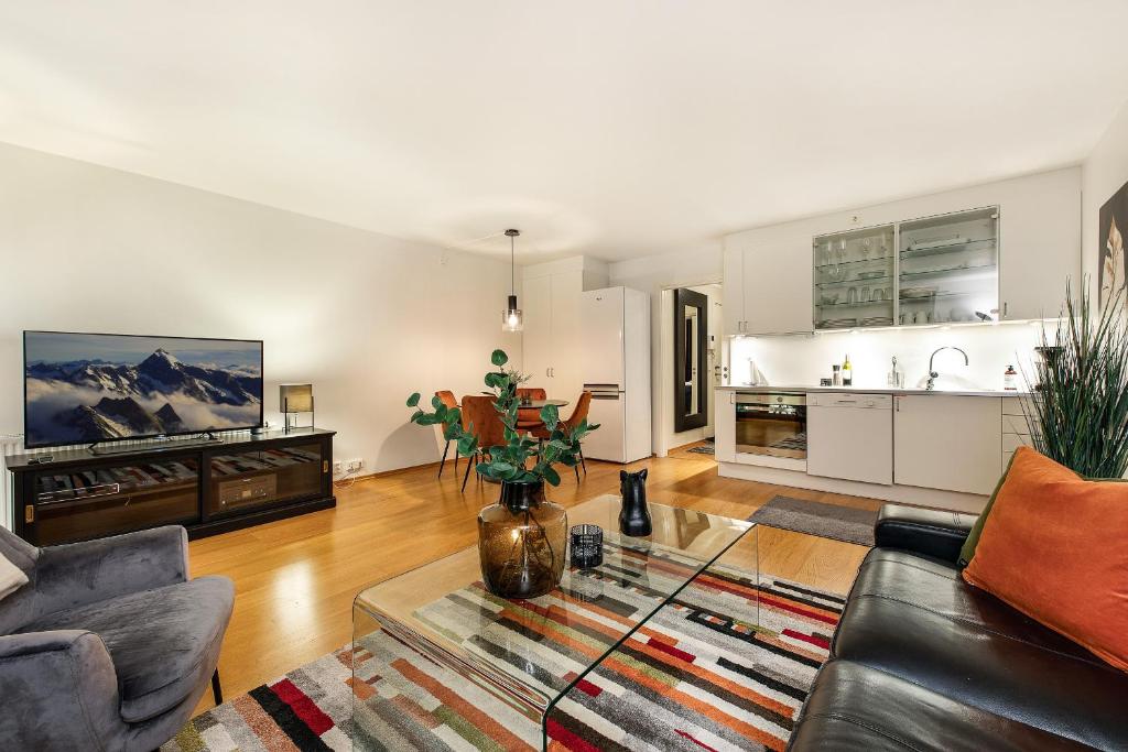 a living room with a couch and a table at Tjuvholmen I, As Home in Oslo