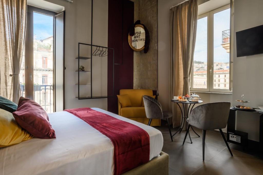 ein Hotelzimmer mit einem Bett, einem Tisch und Stühlen in der Unterkunft Mastropasqua BB in Neapel