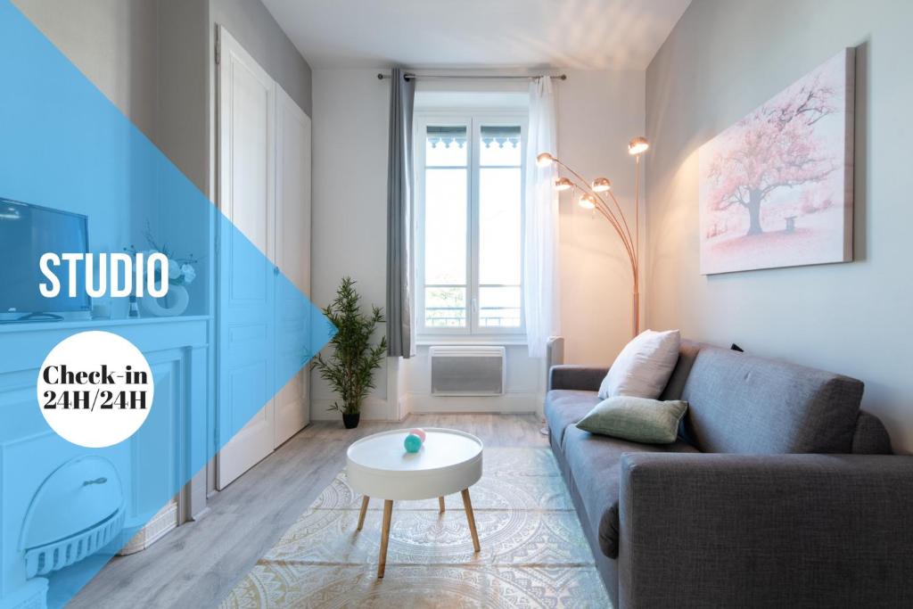 ein Wohnzimmer mit einem Sofa und einem Tisch in der Unterkunft Macé Studio Apartment in Lyon