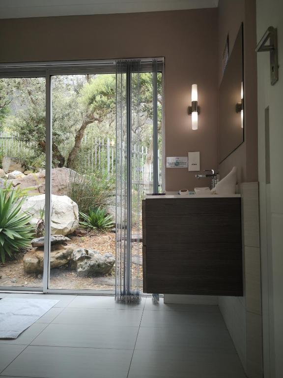 a bathroom with a sink and a large sliding glass door at Diamond House Guesthouse in Cape Town