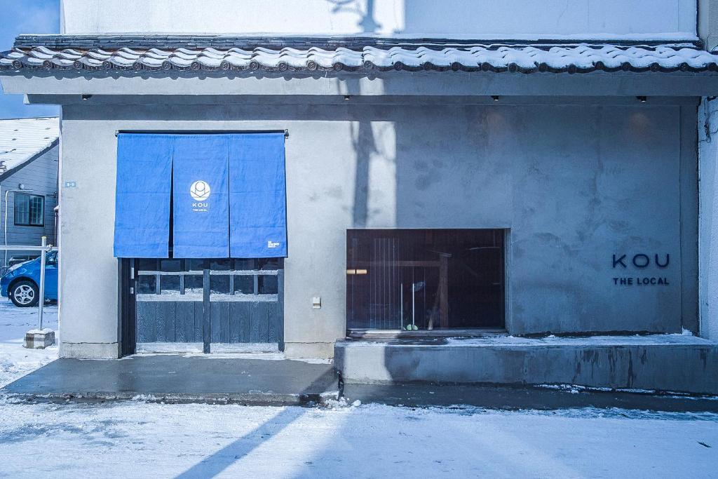ein Gebäude mit einem blauen Schild auf der Seite in der Unterkunft The Apartment Hotels KOU in Otaru