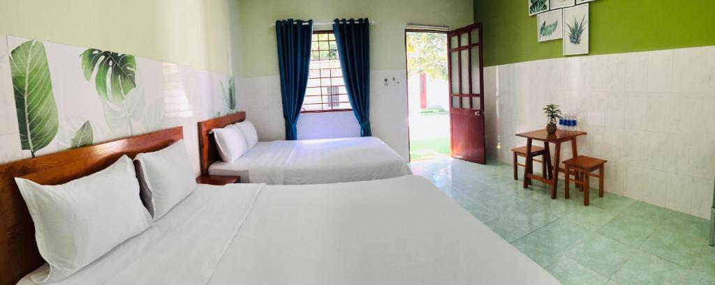 a bedroom with two beds and a window at Eden House & Coffee Con Dao in Con Dao