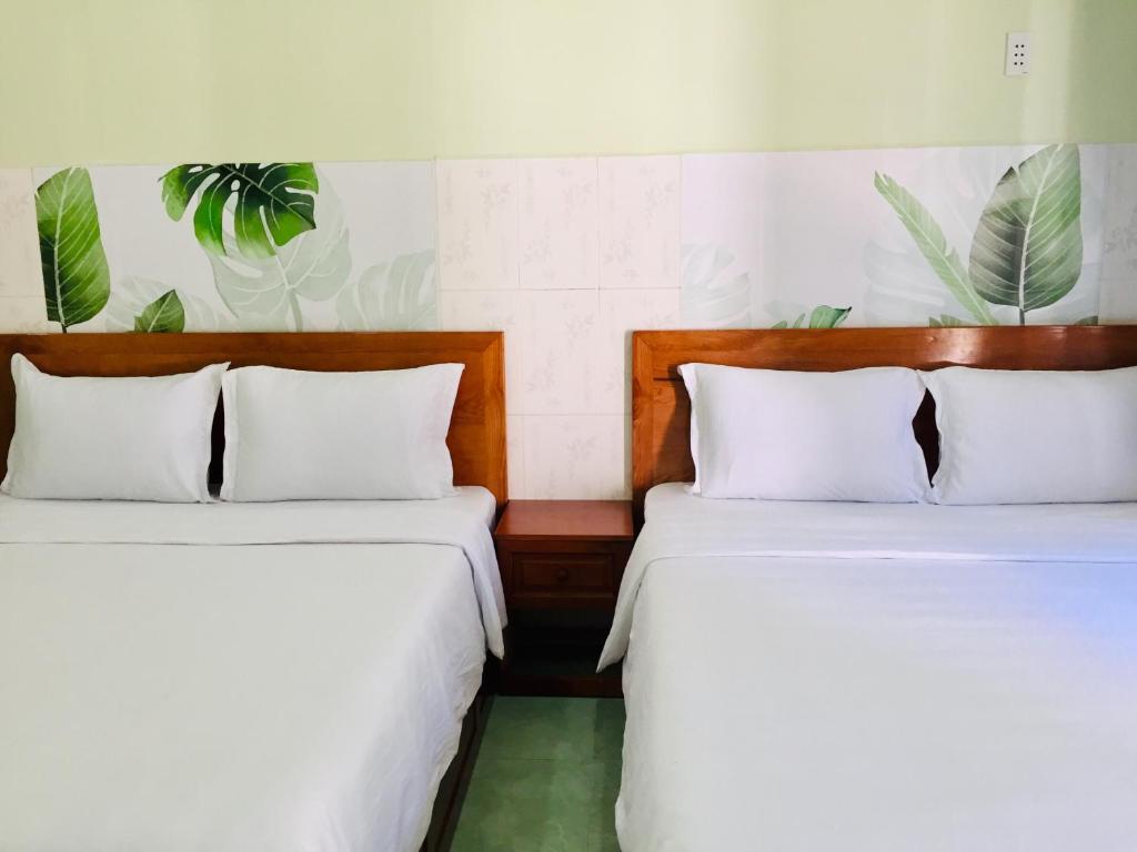 two beds sitting next to each other in a room at Eden House & Coffee Con Dao in Con Dao