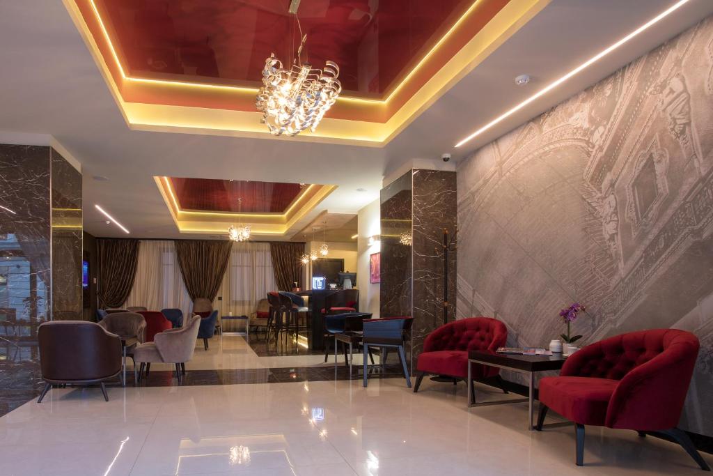 un vestíbulo de un hotel con sillas y mesas rojas en Old Town Hotel, en Timisoara