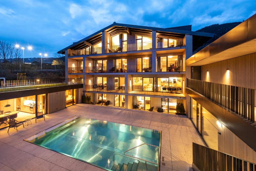 an exterior view of a building with a swimming pool at Emma Deluxe Aparthotel direkt beim Skibus in Piesendorf